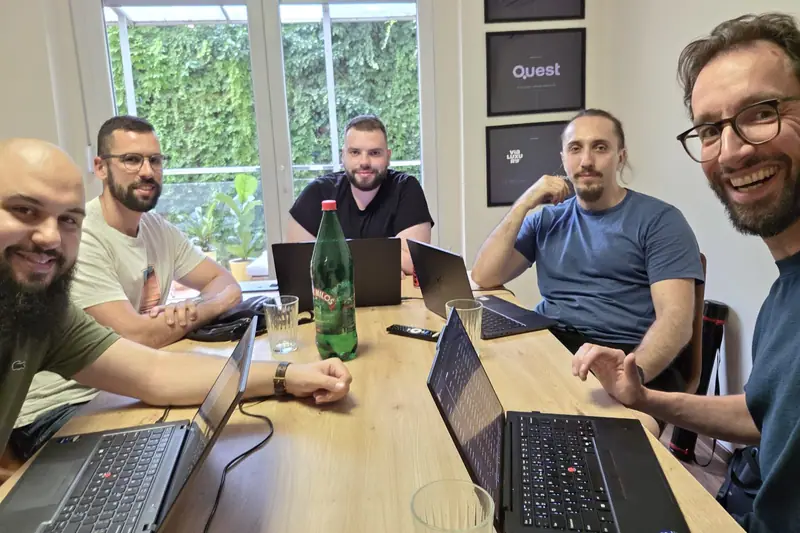 The team around a table with laptops, with Bas on the right