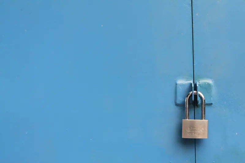 A small padlock on a blue door