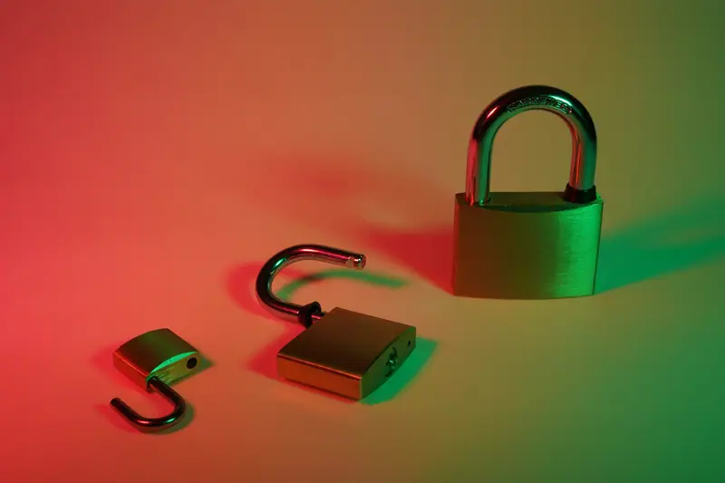One closed and two open padlocks in red and green light