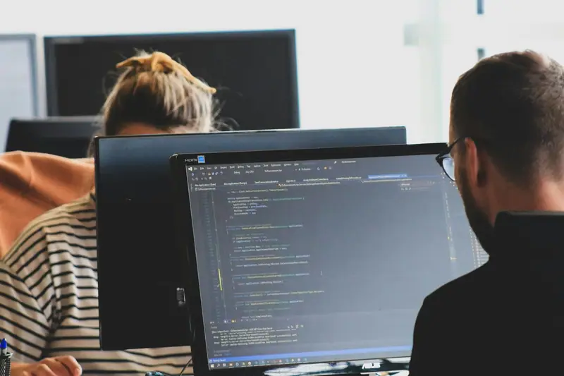 Two developers looking at code on one screen