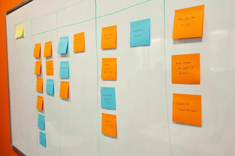 Coloured sticky notes in columns on a wall