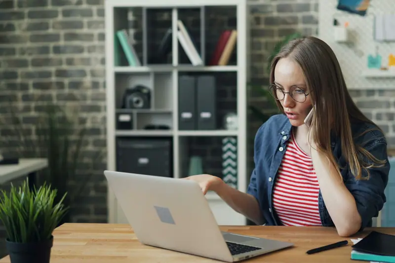 A woman looking doubtfully at her laptop